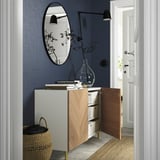 Moderner Eingangsbereich mit BESTÅ Sideboard, Spiegel, Licht, Korb und Vase mit Ästen.