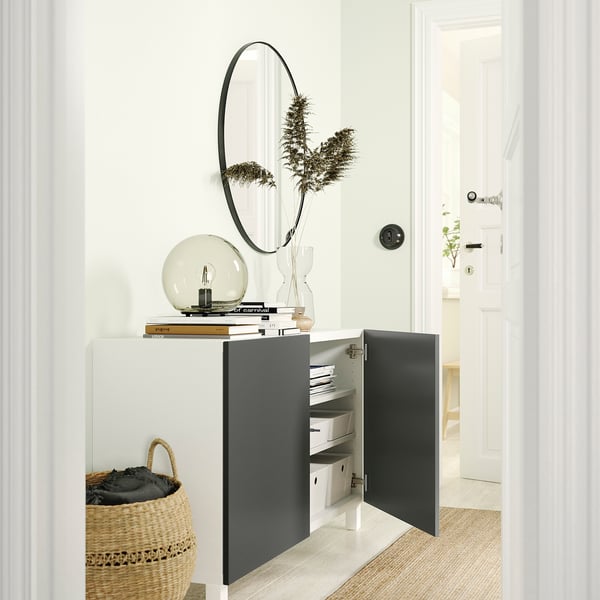 Modernes Zimmer mit BESTÅ-Schrank, getrockneten Pflanzen und Spiegel.
