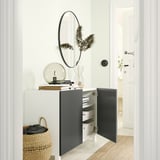 Modernes Zimmer mit BESTÅ-Schrank, getrockneten Pflanzen und Spiegel.