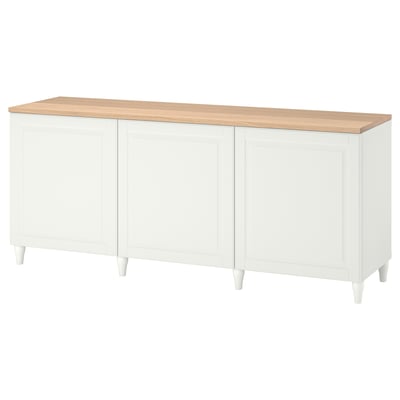 Dieses Bild zeigt ein weißes BESTÅ Sideboard mit Holzarbeitsplatte mit vier Türen und vier Beinen.