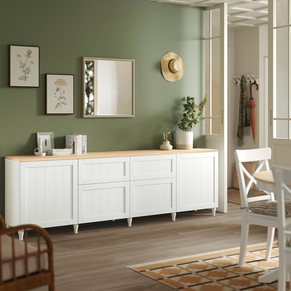 Weißes BESTÅ-Sideboard mit Schubladen, Vasen, Pflanze, zwischen Blumenmustern und Spiegel, große, breite Tischplatte.