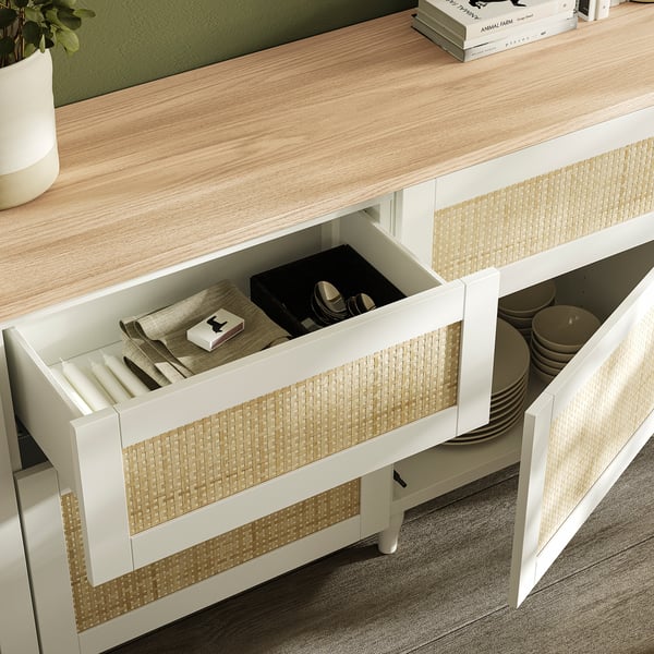 Offene Holzschublade in der Küche zeigt organisiertes Besteck und Geschirr.