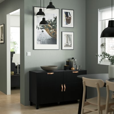 Modernes Wohnzimmer mit BESTÅ Sideboard, Lampen, Kunst, Schale, Krügen, Stuhl. Grüne Akzentwand.