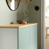 Modernes BESTÅ Sideboard in Hellblau mit Eichenplatte, verziert mit Glasvase, Schale und Glasgefäß, mit Spiegel, Tür und Vorhang.