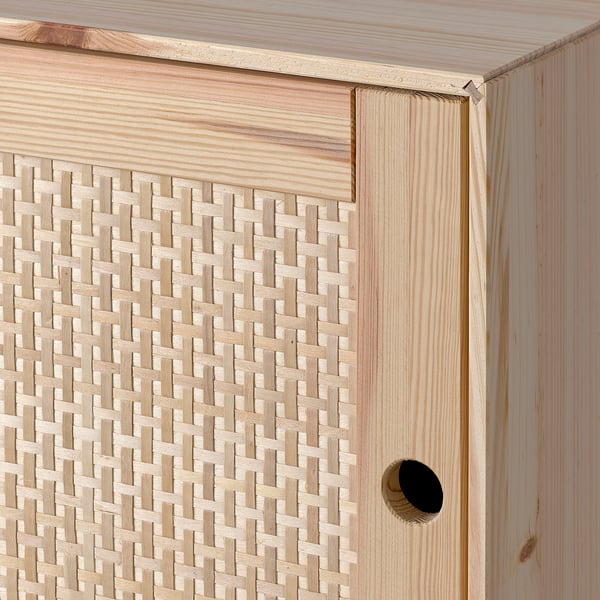Nahaufnahme eines Holzschranks mit geflochtener Korbfront, die hochwertige Verarbeitung zeigt.