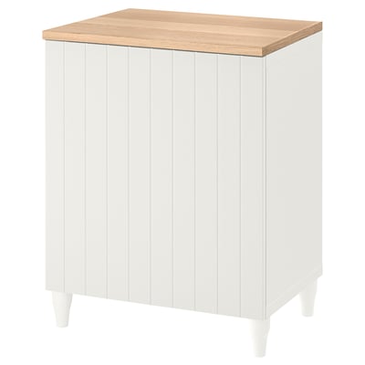 Ein weißer IKEA BESTÅ Schrank mit Eichenplatte. Er hat vertikale Paneele, vier Beine und verstellbare Regale für eine organisierte Aufbewahrung.