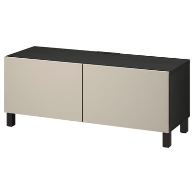 Eine ikea BESTÅ TV-Bank. Es ist rechteckig, oben schwarz, unten beige, mit 2 Türen und 4 Beinen.