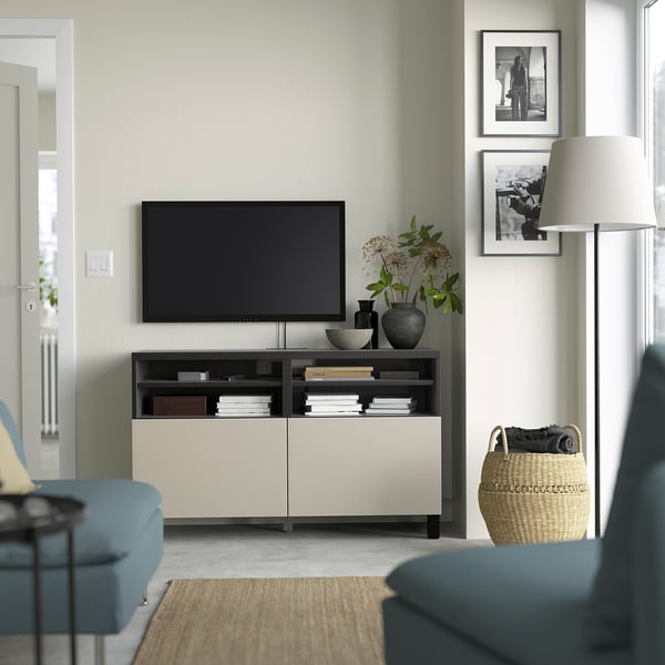Modernes Wohnzimmer mit BESTÅ TV-Bank, TV, Dekor, zwischen Fotos, blauer Couch, Lampe, Weidenkorb.