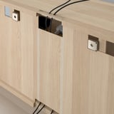 Kabelmanagementsystem in einem TV-Gerät aus Holz mit Schlitzen für eine saubere Kabelführung.
