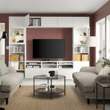 Modernes Wohnzimmer mit BESTÅ-TV, verstellbaren Regalen, Schubladen, Kabelmanagement, Sofas und Couchtisch mit Glasplatte.