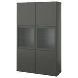Ein dunkelgrauer Schrank von ikea BESTÅ mit Glastüren und Regalen. Es ist ein modernes Design mit schlanken Linien und verstellbarem Stauraum.