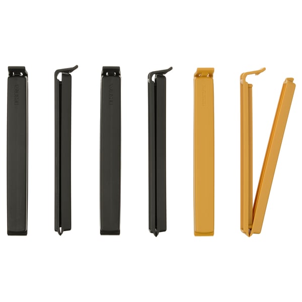 Sechs bunte Dichtungsclips ausgestellt; Drei schwarze und drei goldene, rechteckige Form mit Verriegelungsmechanismus, aus Polypropylen-Kunststoff.