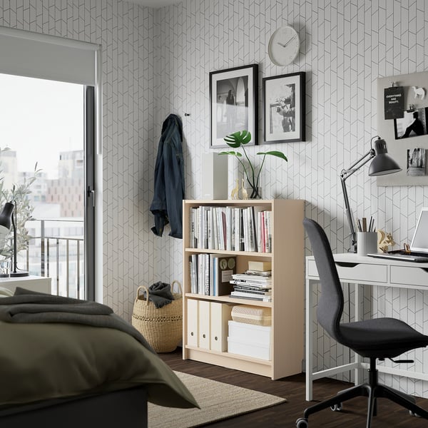 Modernes Schlafzimmer mit BILLY Bücherregal, Schreibtisch und Balkon, geometrische Tapete.