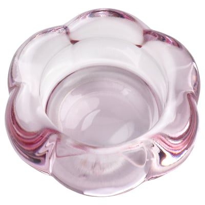 Ein Teelichthalter aus klarem, rosafarbenem Glas namens BLADFÅGEL, inspiriert von einer Blumenform, mit einem modernen Design.