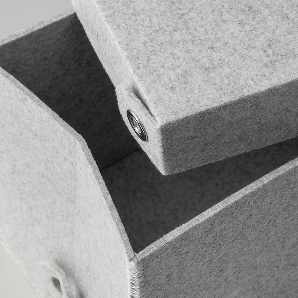 Gestapelte hellgraue Aufbewahrungsboxen aus Stoff mit Deckeldetail, die eine robuste Konstruktion und eine sichere Befestigung zeigen.
