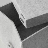 Gestapelte hellgraue Aufbewahrungsboxen aus Stoff mit Deckeldetail, die eine robuste Konstruktion und eine sichere Befestigung zeigen.