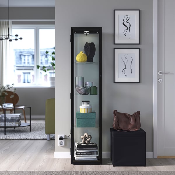 BLÅLIDEN schwarzer Glastürschrank im Wohnzimmer mit Scheinwerfern.