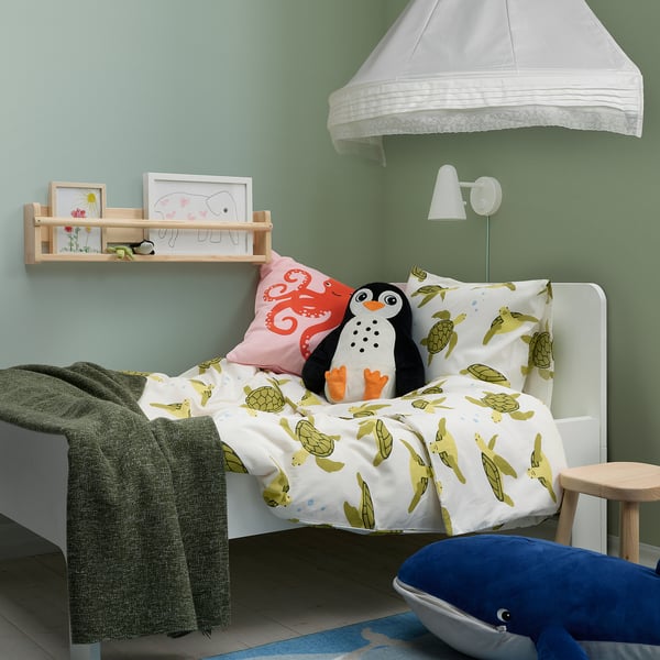 Kinderzimmer mit BLÅVINGAD-Schildkrötenbettwäsche, Oktopuskissen, Pinguinspielzeug und Walkissen.