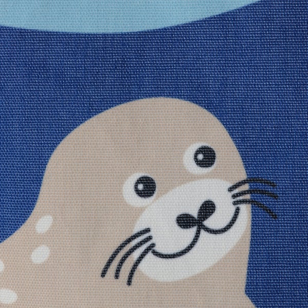 Ein verspielter Seelöwe auf einer blauen Aufbewahrungstasche von blåvidingad. Hergestellt aus recyceltem Meeresplastik.