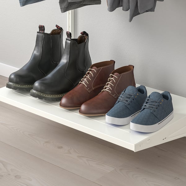 Vier Paar Schuhe in einem weißen BOAXEL-Regal: schwarze Stiefel, braune Stiefel, graue Turnschuhe und blaue Schuhe.
