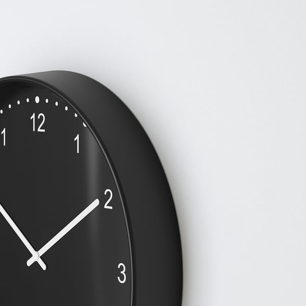 Schwarze runde Wanduhr mit weißen Zeigern und Zahlen, stilvoll und leise, kein Ticken.