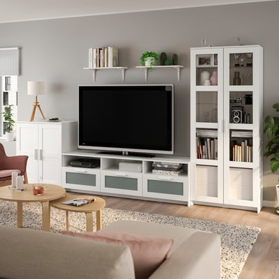 Modernes Wohnzimmer mit BRIMNES Entertainment Center, TV, Dekor, Pflanzen und beigem Sofa.