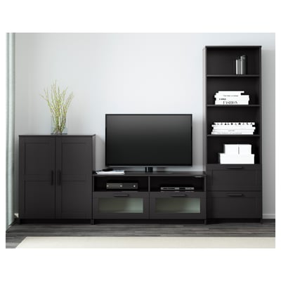 Moderner TV-Ständer mit Flachbildschirm, Schubladen, Regalen, schwarzen Schränken, Bücherregal mit Dekor und Büchern.