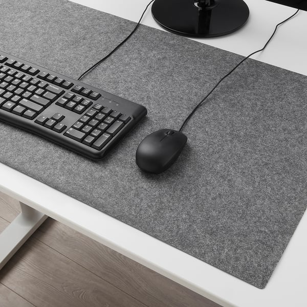 BRYTAREN schwarzes Mauspad auf dem Schreibtisch mit Tastatur, Maus und Lampe. Große, filzige Oberfläche mit Silikonpunkten.