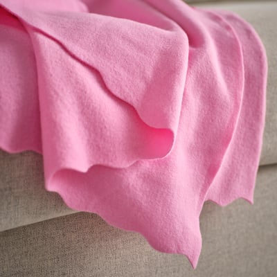 Leuchtend rosa gefaltete Fleecedecke, weiche, rechteckige Form, schlichtes Design.