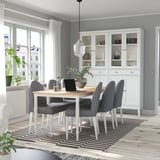 Modernes Esszimmer mit Holztisch, grauen Stühlen und gestreiftem Teppich.