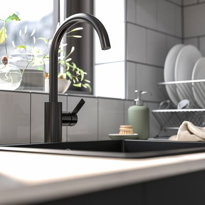 Moderne schwarze Küchenarmatur mit hohem Lichtbogenauslauf, schlankem Design, in der Nähe des Waschbeckens positioniert, umgeben von Tellern und Seifenspender.