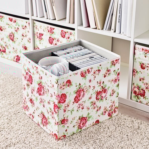Blumen-Aufbewahrungsbox auf dem Regal mit Kopfhörern und Kabeln, Teil der Kallax-Einheit.