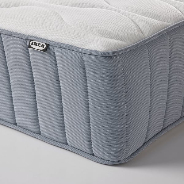 Nahaufnahme einer hochwertigen Ikea-Matratze, die ihre strukturierte Oberfläche und robuste Konstruktion mit sichtbaren Nähten und dem IKEA-Logo-Etikett zeigt.