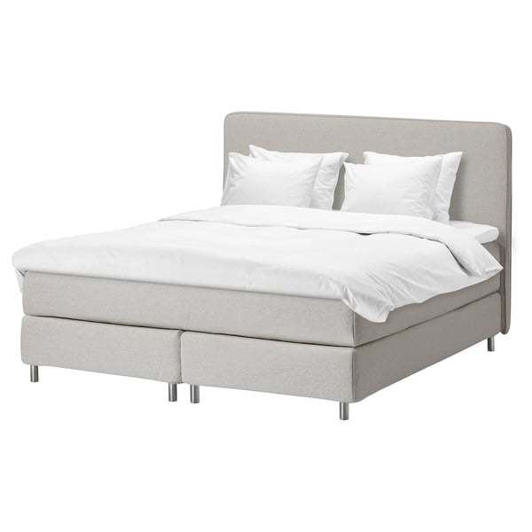 Modernes, minimalistisches Bett aus hellgrauem Stoff, gepolstertes Kopfteil, weiße Bettwäsche, vier Metallbeine, schlankes Design.