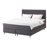 Ein graues DUNVIK-Bett mit weichem Kopfteil, vollständig gepolstert und einer weißen Bettdecke.