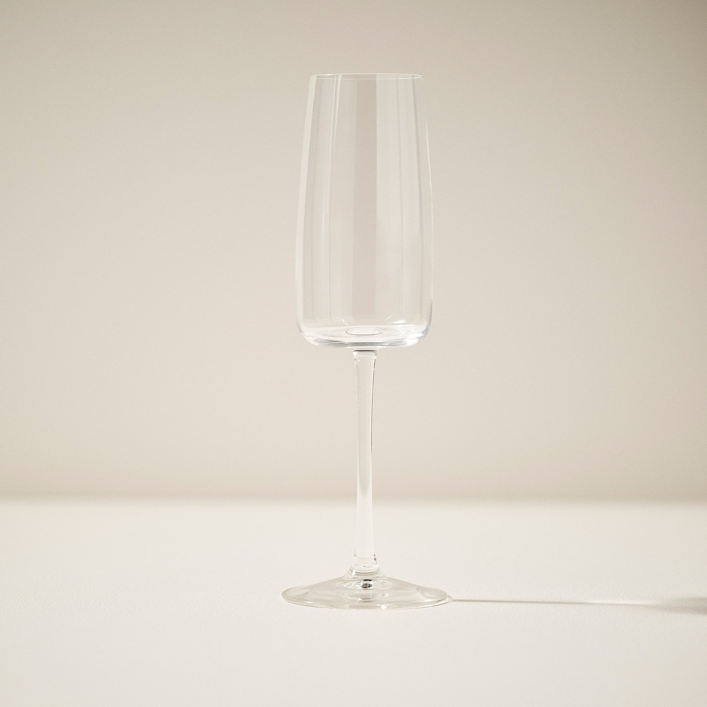 Einzelne, elegante Champagnerflöte mit schlankem, klarem Design, aufrecht stehend.