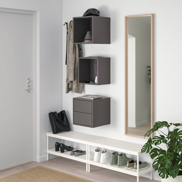 Graue EKET-Wandschränke, Schuhregal, großer Spiegel, Pflanze und gewebte Matte im Eingangsbereich.