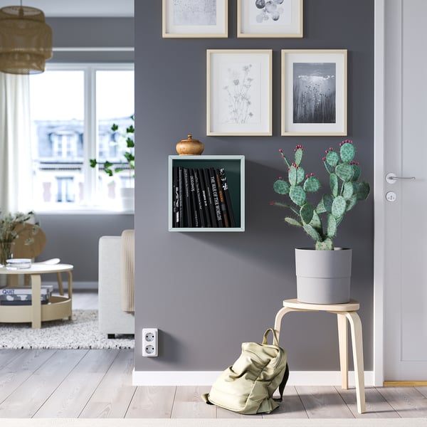 Moderner Raum mit EKET-Stauraum, Schallplatten, Anlage. Rucksack unter Kaktus, Hocker, Kunst, Stadtansicht.