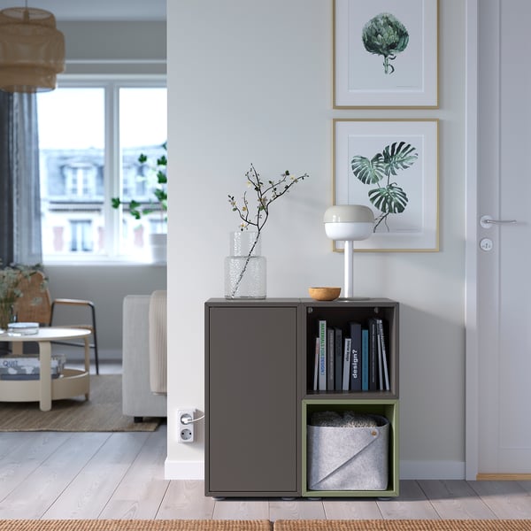 Modernes Wohnzimmer mit grauem EKET-Aufbewahrungsschrank, Büchern, Lampe und Fensterblick. Hell und organisiert.