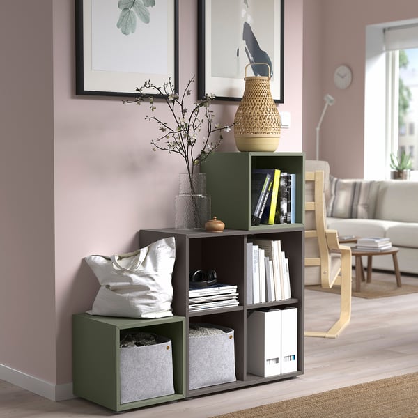 Grünes EKET-Bücherregal mit Büchern, Tasche, Vase und Kunst. Minimalistisches Design.
