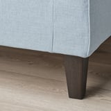 Nahaufnahme des Sofas: hochwertiger hellgrauer Stoff, Taschenfedern für mehr Komfort, robuste Holzbeine.