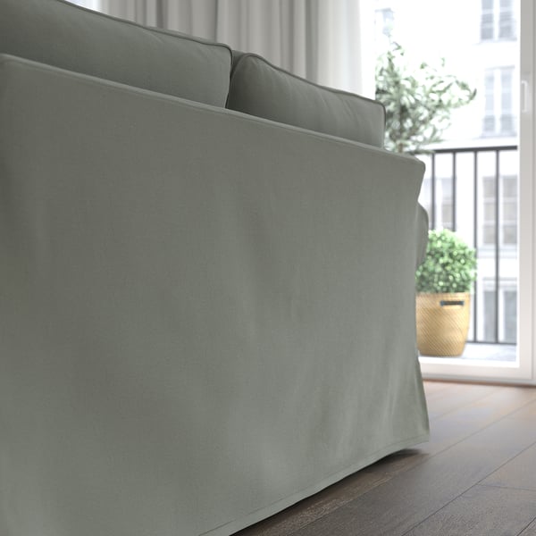 Graues EKTORP-Sofa in der Nähe des Fensters, mit Blick auf die Stadt. Kuschelige, dicke Kissen.