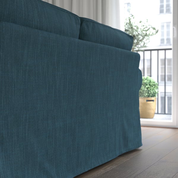 Dunkelblaues Sofa in der Nähe eines Fensters mit einer Pflanze.