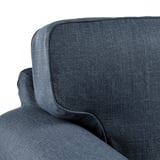 Dunkelgraue gepolsterte Sofaecke mit weichen Kissen und feinen Nähten.