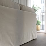 Ein gemütliches EKTORP-Sofa, das von hinten gezeigt wird und ein dickes Kissen für mehr Komfort bietet. Hellgrauer Chenillebezug mit weicher, leicht reflektierender Oberfläche.