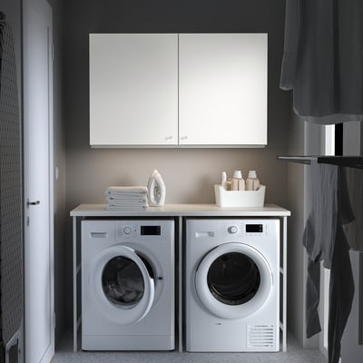 Moderne Wäscherei mit weißen ENHET-Geräten - Waschmaschine, Trockner, Arbeitsplatte und Schränke.