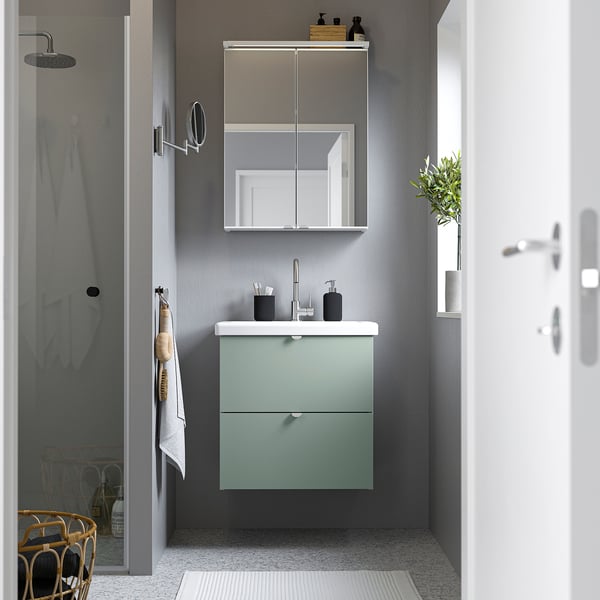 Modernes Badezimmer mit ENHET hellgrünem Schrank und Spiegelschrank, Edelstahlarmatur und Glasdusche.