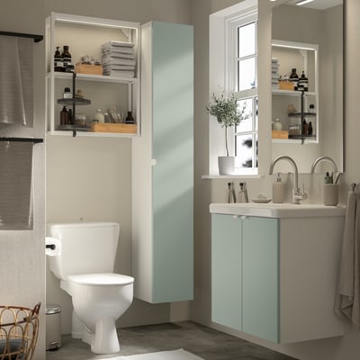 Modernes Badezimmer mit grau-grünem Stauraum ENHET, Hochschrank, Wandrahmen und Waschbecken. Organisierte Regale, Spiegel und Fenster.