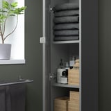 Offener Aufbewahrungsschrank mit gefalteten Handtüchern und Hygieneartikeln mit grauen und Holzelementen.