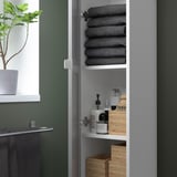 Neues Image moderner grauer Hochschrank mit Regalen, in dem Handtücher und Flaschen aufbewahrt werden.